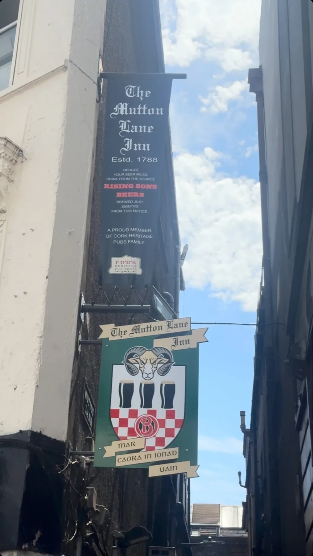 The Mutton Lane Inn sign hanging above the narrow lane