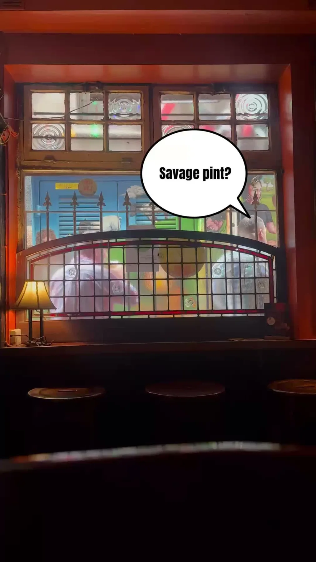 The pub interior with coloured light through a stained glass style window